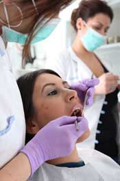 zubar sa pacijentom na stolici, stomatoloska sestra u pozadini